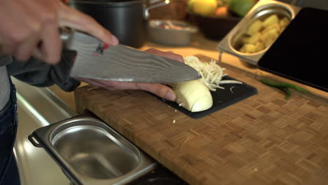 Dolly-Out-Shot-of-Female-Hands-Slicing-a-White-Onion