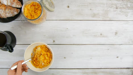 Top-View-Eating-Corn-Flakes-from-Bowl-at-Breakfast