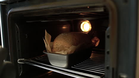 POV-of-Female-Hands-Taking-Freshly-Baked-Bread-Out-of-Oven