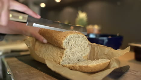 Close-Up-of-Female-Hands-Slicing-Loaf-of-Bread-
