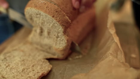 Extreme-Close-Up-of-Female-Hands-Slicing-Loaf-of-Bread-