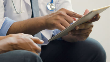 Doctor-Usando-Tableta-Mientras-Habla-Con-El-Paciente