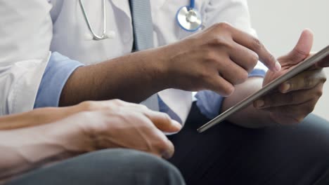 Doctor-Using-Tablet-Whilst-Talking-to-Patient