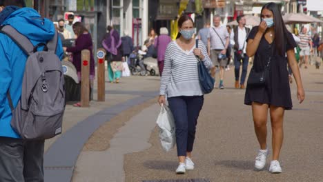 Two-Women-In-face-Masks-Walking-Down-Busy-Cornmarket-Street-In-Oxford