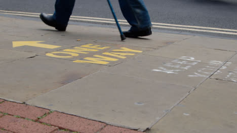 Close-Up-Shot-of-Pedestrians-Feet-Walking-Over-One-Way-Pavement-Marking-In-Oxford-England
