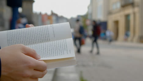 Close-Up-Shot-of-Someone-Reading-a-Book-On-Clarendon-Building-Steps-In-Oxford