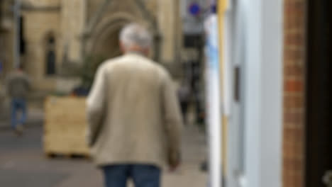 Defocused-Shot-of-Elderly-Man-Walking-Down-Quiet-Street-In-Oxford