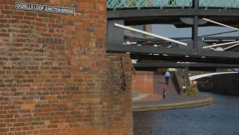 Panning-Shot-of-Someone-Walking-Alongside-Canal-In-Birmingham-