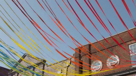 Low-Angle-Panning-Shot-of-Decorative-Ribbons-Tied-to-Building-