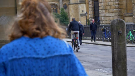 Rack-Focus-Shot-of-Cyclist-Passing-Radcliffe-Camera-Building-In-Oxford