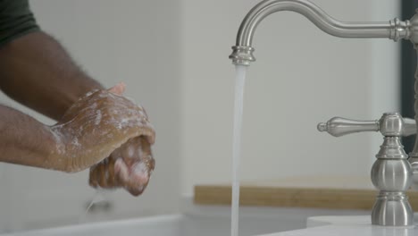 Man-Cleaning-His-Hands-with-Soap-Under-Running-Tap-Water