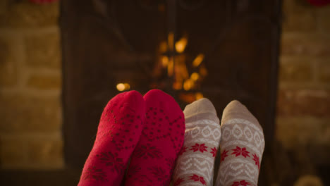 Close-Up-Shot-of-Couples-Feet-In-Front-of-Burning-Fireplace