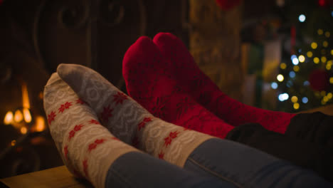 Close-Up-Shot-of-Couples-Feet-In-Front-of-Cosy-Warm-Fireplace