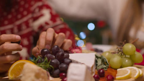 Extreme-Close-Up-Shot-of-Christmas-Table-Top-Food-Spread-with-Couple-In-Background