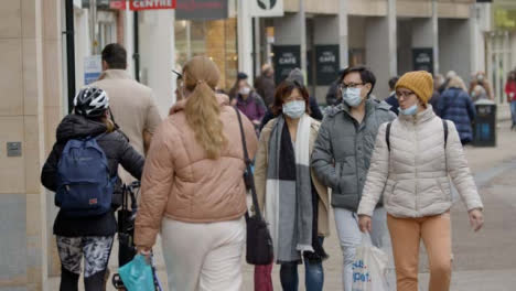 Long-Shot-of-People-Wearing-Face-Masks-Walking-Down-Busy-Street-In-Oxford-England