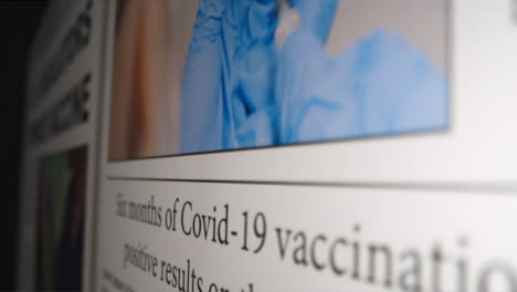Sliding-Extreme-Close-Up-Shot-of-Covid-19-Vaccine-News-Article-On-Computer-Screen