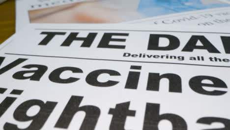 Sliding-Extreme-Close-Up-of-Newspaper-Front-Pages-with-Covid-19-Effective-Vaccine-Headlines