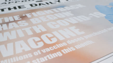 Schieben-Sie-Extreme-Nahaufnahmen-Eines-Zeitungsstapels-Mit-Wirksamen-Schlagzeilen-Des-Covid-19-Impfstoffs