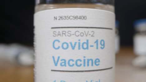 Sliding-Extreme-Close-Up-Shot-of-Coronavirus-Vaccine-Vial-