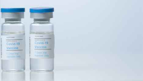 Sliding-Close-Up-Shot-of-Two-Vials-of-Covid-19-Vaccine-with-Right-Copy-Space