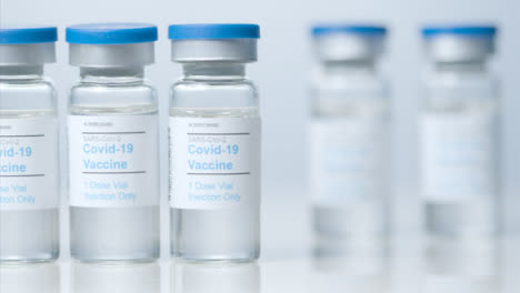 Sliding-Close-Up-Shot-of-Four-Vials-Containing-Covid-19-Vaccine-