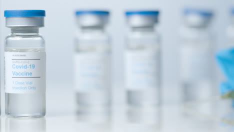 Sliding-Close-Up-Shot-of-Five-Vials-Containing-Covid-19-Vaccine-