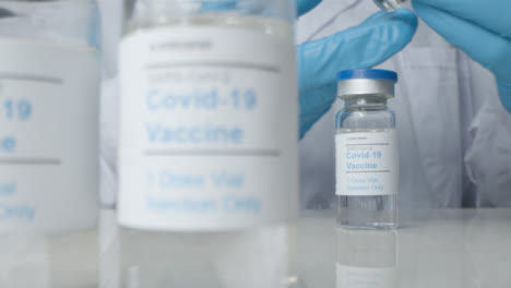Sliding-Close-Up-Shot-Revealing-Doctor-Checking-Vials-of-Covid-19-Vaccine
