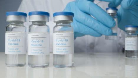 Sliding-Close-Up-Shot-Revealing-Doctor-Checking-Vials-of-Coronavirus-Vaccine