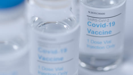 Sliding-Extreme-Close-Up-Shot-of-Several-Coronavirus-Vaccine-Vials-