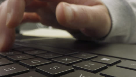 Sliding-Extreme-Close-Up-Shot-of-Pair-of-Male-Hands-Drinking-Coffee-and-Using-Laptop