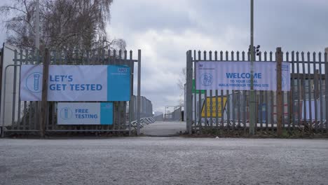 Low-Angle-Wide-Shot-of-Cars-Driving-Past-Entrance-to-COVID-19-Testing-Site