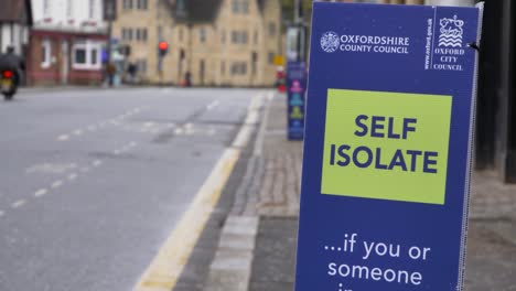 Handheld-Close-Up-Shot-of-Self-Isolate-Sign-In-Oxford-City-Centre
