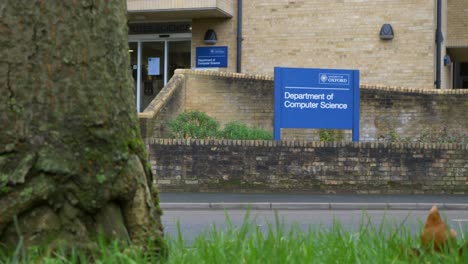 Low-Angle-Wide-Shot-of-Cars-Passing-University-of-Oxford-Computer-Science-Department