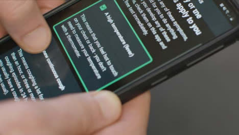 Extreme-Close-Up-of-Hands-Using-COVID-Symptom-Checker-Smartphone-App