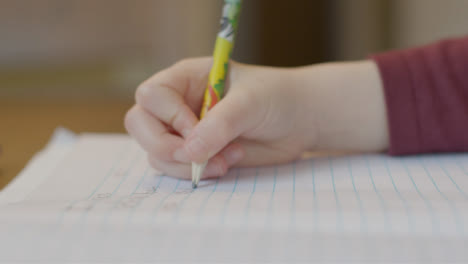 Close-Up-Shot-of-Childs-Hand-As-They-Write-On-Piece-of-Paper