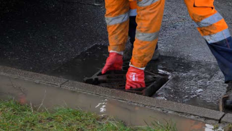High-Angle-Shot-of-Drainage-Worker-Placing-Down-Storm-Drain-Cover
