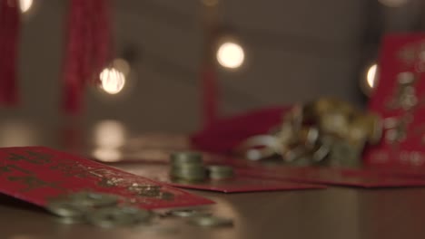 Sliding-Close-Up-Shot-of-Chinese-New-Year-Red-Pockets-and-Coins