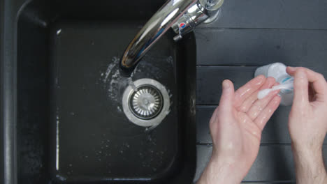 Top-Down-Shot-of-Male-Hands-Washing-Hands-with-Soap