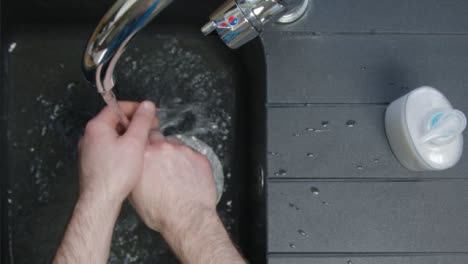 Top-Down-Shot-of-Male-Hands-Turning-On-Tap-and-Washing-Hands
