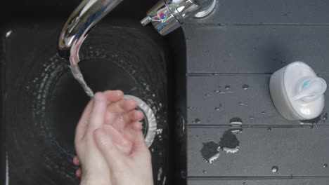 Top-Down-Shot-of-Male-Hands-Turning-Washing-Underneath-Running-Tap