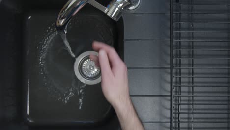Top-Down-Shot-of-Male-Hands-Pouring-Washing-Liquid-into-Sink-Under-Running-Tap