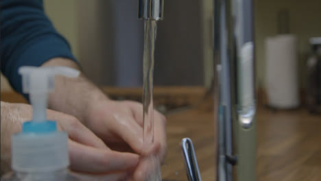Close-Up-Shot-of-Male-Hands-Washing-Hands-Running-Under-Tap-