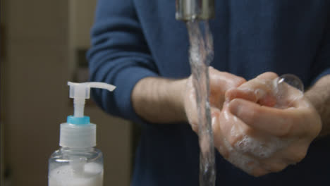 Close-Up-Shot-of-Male-Hands-Washing-Under-a-Running-Kitchen-Tap-with-Soap