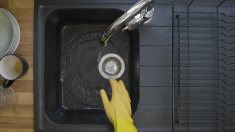 Top-Down-Shot-of-Male-Hands-Pouring-Washing-Liquid-into-Sink-Under-a-Running-Tap