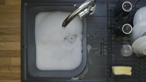 Top-Down-Shot-of-Soapy-Water-Running-Down-a-Sink-Plug-Hole-Leaving-Bubbles-Behind