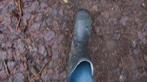 POV-Shot-Looking-Down-at-Feet-Walking-On-Muddy-Footpath