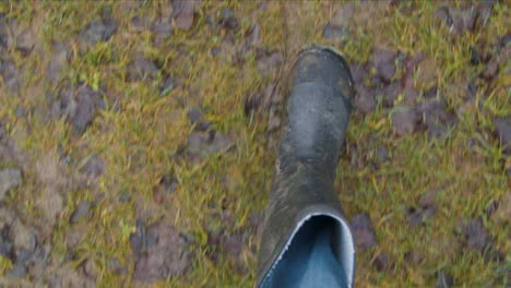 POV-Shot-Looking-Down-at-Boots-Walking-On-Muddy-Footpath