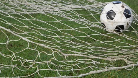Medium-Shot-of-Soccer-Ball-Rolling-into-Goal-Net-Before-a-Foot-Rolls-It-Out-