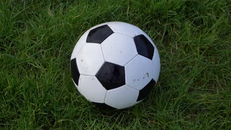 Handheld-Close-Up-Shot-of-Soccer-Ball-On-Grass