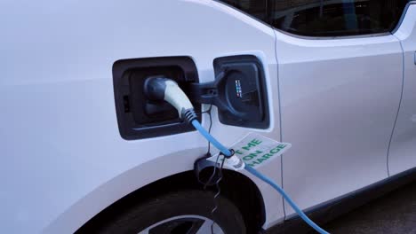 Tilting-Shot-Looking-Up-at-Charging-Cable-Plugged-into-Electric-Car-